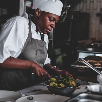 A cook finishing a dish by hand